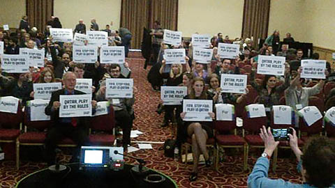 Higher education conference delegates hold up placards reading 'Qatar play by the rules'