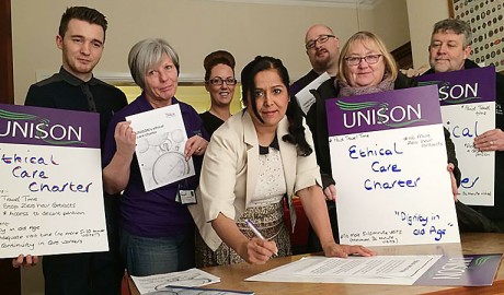 Bolton South East MP Yasmin Qureshi signs a a print-out of UNISON's Ethical Care Charter, surrounded by stewards from Bolton UNISON