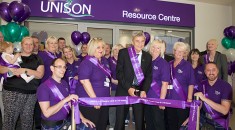 Dave Prentis cuts ribbon in front of resource centre, surrounded by members