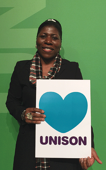 UNISON member Margaret Greer stands holding a placard that says 'love UNISON'