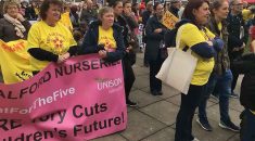 Cowd with banners at Salford nurseries rally in March