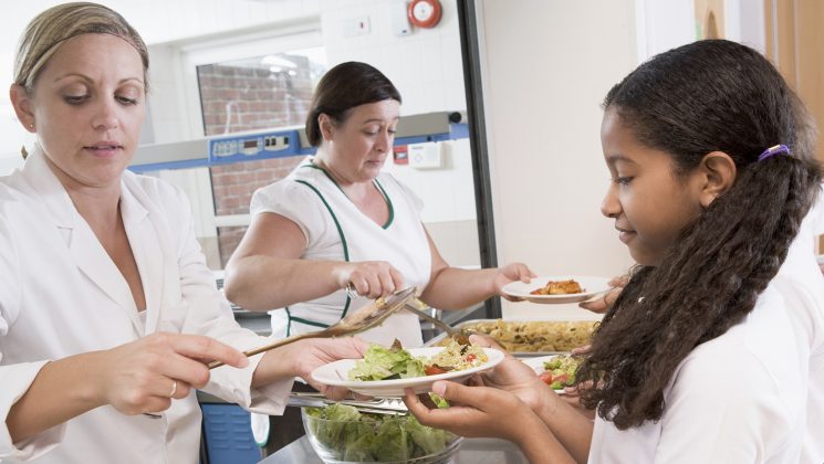 Staff serving school meals to pupils