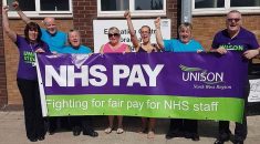 Members standing with banner reading: NHS pay – fighting for fair pay for NHS staff