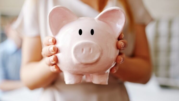 A woman holds a piggy bank