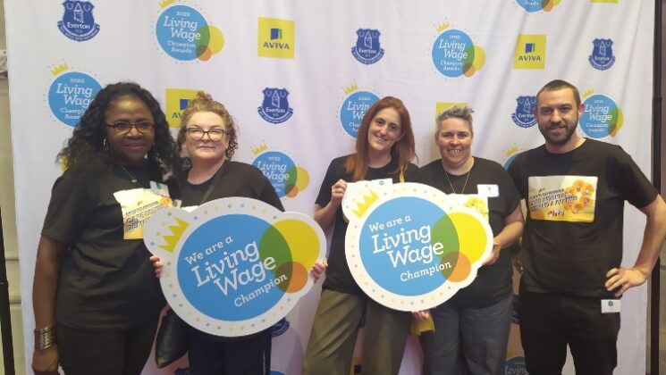 Five UNISON members hold signs saying 'we are a living wage champion'