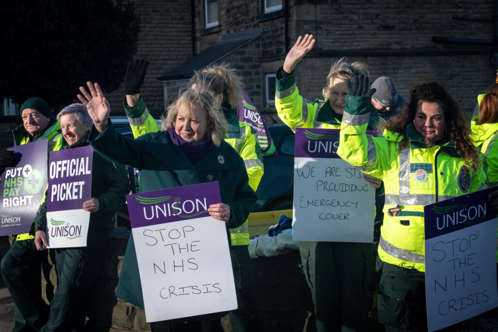 Christina McAnea stand on Wath ambulance station picket line with striking ambulance workers while waving at a honking car passing by