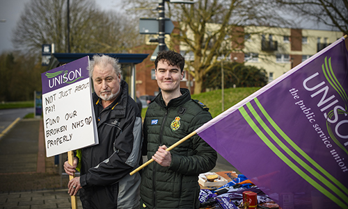 Two male pickets with placard and flag