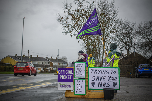 Pickets in the rain, by a road
