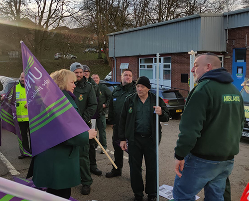 Christina McAnea at Longley Ambulance Station in Sheffield, with a UNISON flag, talking to members who are on picket duty