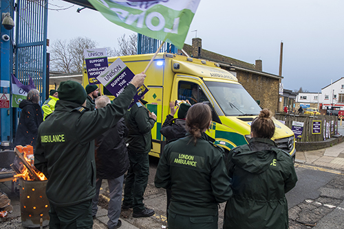 Pickets at Greenwich stand clear as emergency cover ambulance leaves