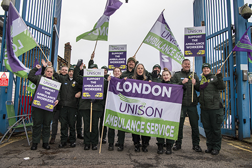 Sara Gorton with UNISON flag, with pickets at Greenwich