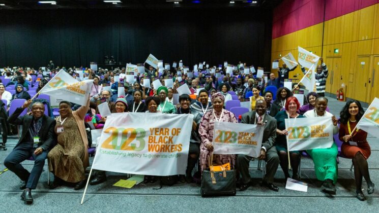 Delegates at UNISON national Black members conference hold up '2023 year of Black workers' banners