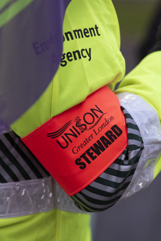 Orange UNISON steward armband round a high-viz jacket arm