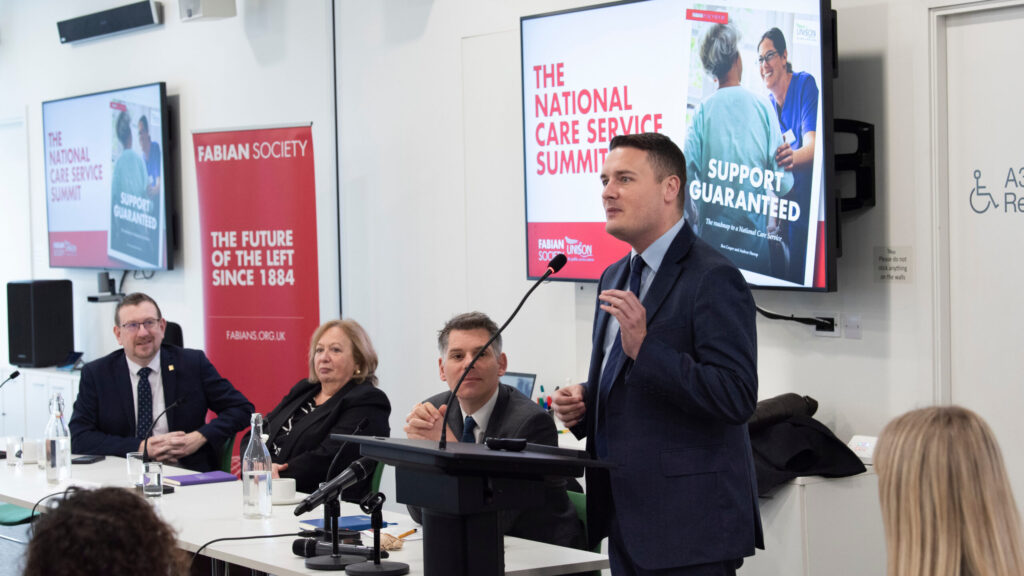 Wes Streeting MP, shadow secretary of state for health and social care, speaks from the podium at the Fabian Society national care service summit