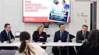 From left to right, Andrew Gwynne MP, Christina McAnea, Wes Streeting MP and Andrew Harrop - general secretary of the Fabians society sit at the top table of the national care service summit hosted at UNISON centre, a national care service summit graphic on a tv screen behind them.