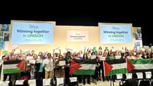 UNISON women's conference delegates hold Palestinian flags and signs reading 'ceasefire now'