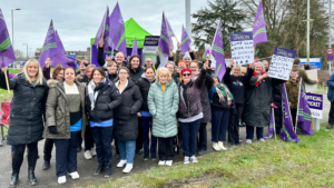 Sodexo workers on a picket line, holding purple UNISON flags