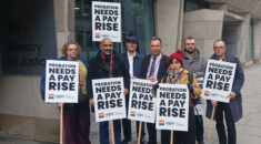 A group of people standing with placards with the words 'probation needs a pay rise'